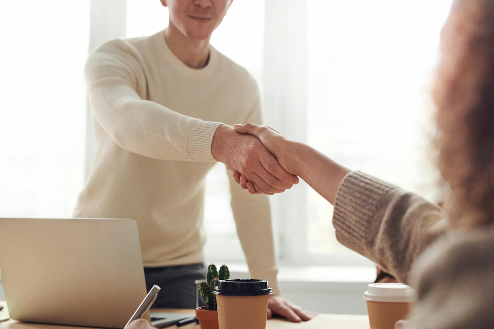 Colleghi che collaborano attorno a una scrivania in un ambiente di lavoro informale